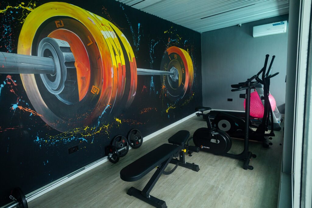Brum Height 6: Residents' fitness room with workout equipment and a wall mural